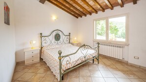 A bedroom with a bed, nightstands, a window, and a radiator. - Panorama-Ferien-Toscana
Your vacation home in Tuscany (massa marittima)