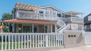 A two-story house with a balcony, a covered patio, and a gated entrance. - Apartment Ema (Ližnjan)
