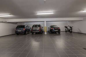 A parking garage with three cars and a motorcycle parked in a row. - Vis-Ahr-Vis Penthouse (Bad Neuenahr)