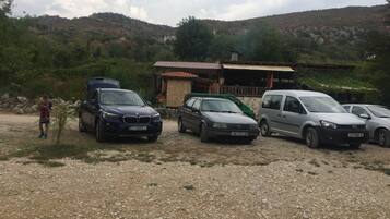 A gravel parking area with several cars parked.