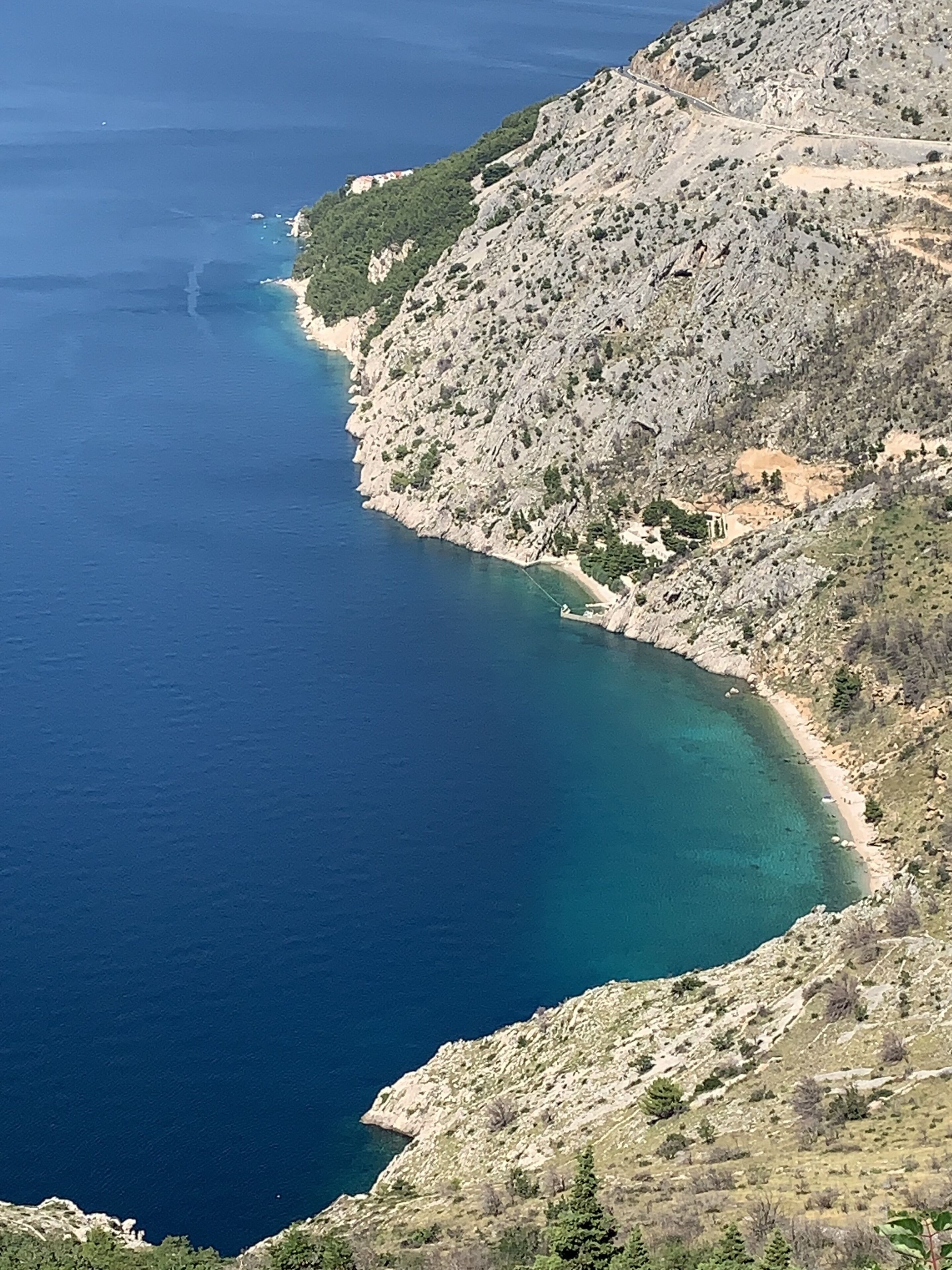 Un paisaje costero con costa rocosa y aguas azules cristalinas.