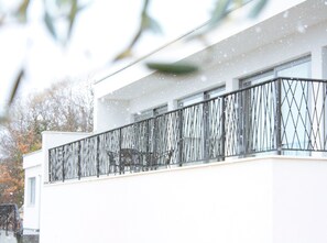 Un bâtiment moderne doté d’un balcon et arborant un logo en forme d’arbre.