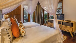 A bedroom with two beds, a TV, and a wooden cabinet.