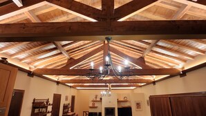 Ruokailutila, jossa on korkea puukatto ja koristeelliset kattokruunut.