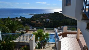 A balcony with a view of the sea, a swimming pool, and surrounding greenery. - Villa Orea Thea with pool, German standard for up to 6 people (Syvota)