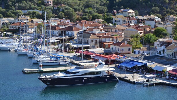 A marina with multiple boats docked, surrounded by residential buildings and a hilly backdrop. - Villa Orea Thea with pool, German standard for up to 6 people (Syvota)