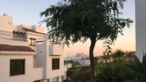Un edificio moderno con fachada blanca, múltiples ventanas y un balcón.