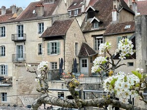 A row of stone buildings with traditional architecture, featuring balconies and shutters.