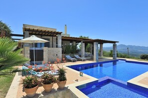 A modern villa with a swimming pool, outdoor seating, and a view of the mountains. - Villa Pegasus with fantastic panoramic views near Rethymnon (Rethymno)