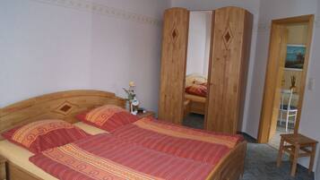 Una camera da letto con un letto in legno, un armadio in legno e un piccolo tavolino in legno.