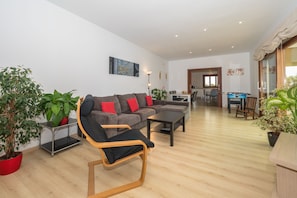 Una sala de estar moderna con un sofá, una silla, una mesa de centro y plantas en macetas.