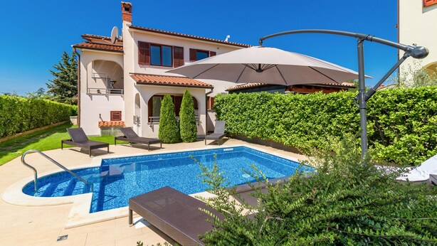 Une villa moderne dotée d’une piscine, d’un espace extérieur aménagé et d’un jardin bien entretenu.
