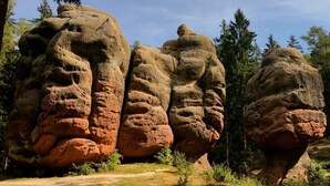 Une formation rocheuse naturelle, accessible par un sentier de terre.