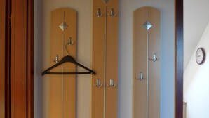 Una habitación con tres puertas de madera, cada una con un gancho para abrigos y un pequeño adorno con forma de diamante.