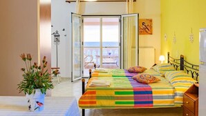 A bedroom with a bed, a potted plant, a view of the sea, and a balcony. - Beach house Tolis at Pelekas Beach (Pelekas Κέρκυρα)