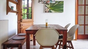 A dining area with a wooden table, chairs, a bench, a stained glass pendant light, a cabinet, and a wall-mounted picture. - Spacious vacation home with garden, approx. 150 m to the lake, with bathing facilities (Lavena Ponte Tresa)