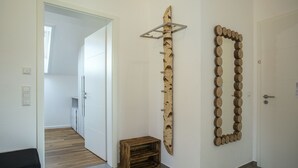 A hallway with a wooden crate, a wooden wall art piece, and a mirror. - Vacation magic  (Neukirch)