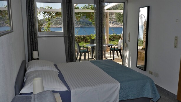 Un dormitorio con cama, ventana y vistas al exterior.