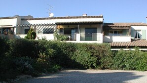 Ein Wohngebäude mit Kiesweg, überdachter Veranda und Satellitenschüssel.