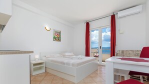 Un dormitorio moderno con cama, mesita de noche y vista al mar.
