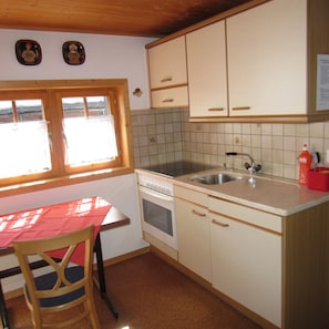 Compact kitchen with a window, stove, sink, and countertop, perfect for preparing meals.