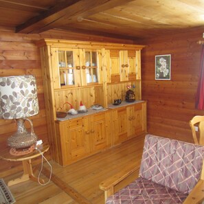 Cozy room with a wooden cabinet, patterned table lamp, and cushioned bench.