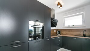 A modern kitchen with dark cabinets, a built-in oven, and a window above the sink. -  Relax with a view of the sea !! (Vantacici-Malinska)