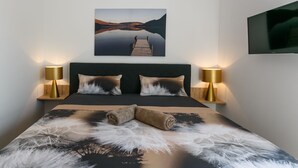 A neatly made bed with a feathered throw, two bedside lamps, and a painting of a lake and dock above the bed. -  Relax with a view of the sea !! (Vantacici-Malinska)