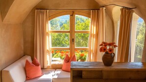 A cozy room with a built-in bench, a wooden cabinet, and a window with curtains.