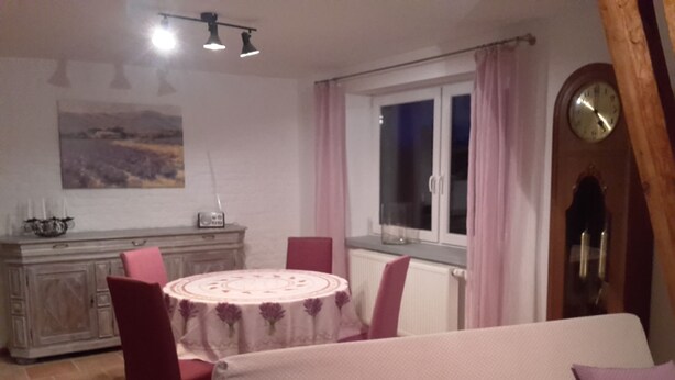 Ein Essbereich mit einem runden Tisch, Stühlen und einem Schrank.