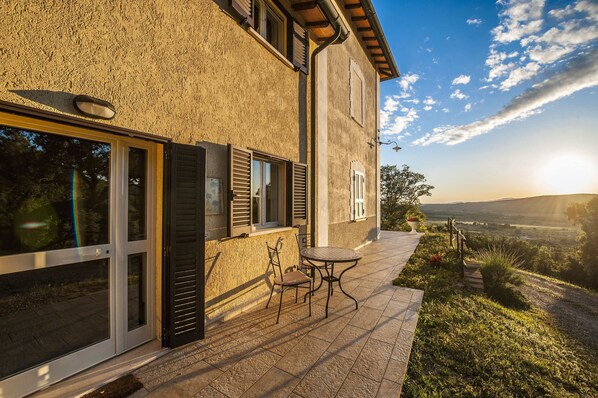 A house with a patio, a table, and chairs.