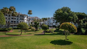A hotel complex with multiple buildings, a well-maintained lawn, and various trees. - Outdoors apartment labandera at the gates of Marbella (Mijas Costa)