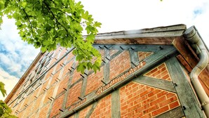 Un bâtiment en briques avec des poutres en bois apparentes, et l’inscription « Hundling’s House » visible sur la façade.