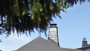Un bâtiment en pierre avec un toit à pignon et une cheminée.