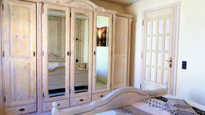 Une chambre à coucher avec un lit, une armoire et une porte.