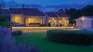 A residential property with a stone facade, multiple entryways, and outdoor seating areas. - Villa Gardena with heated pool (Kvarner - Vrh) (Vrh)