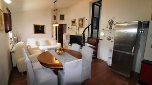 A compact living space with a dining area, a sofa, a TV, and a refrigerator. - Peaceful Haven - 3BR/1BA Apt, Sleeps 5, Parking 1 (Banjole)