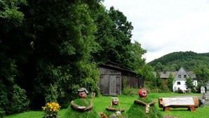 A rural landscape with a wooden barn, a white house, and a signboard. - Pure relaxation with steam shower and whirlpool in a comfort cottage  (Bad Berleburg)