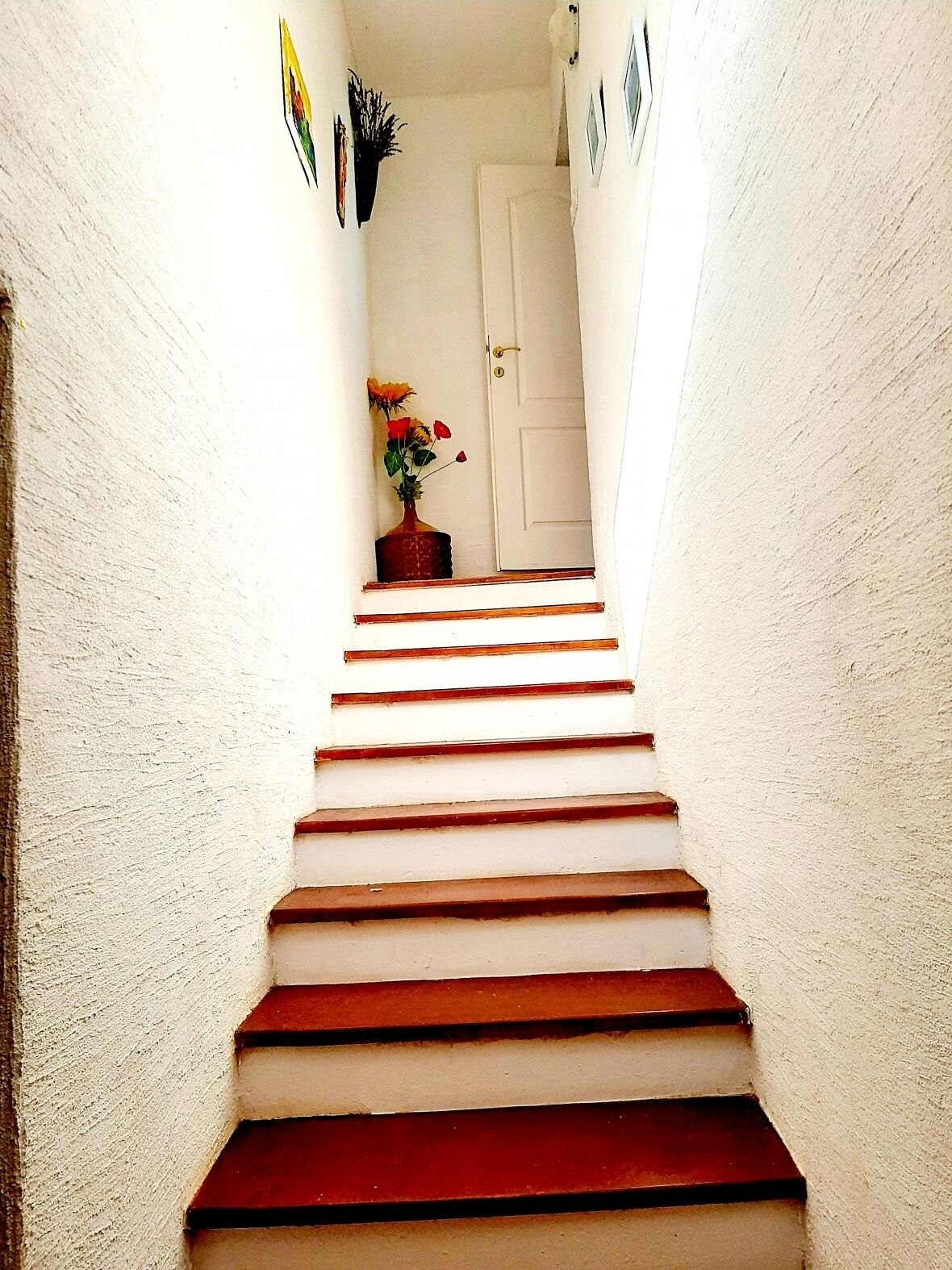 A staircase with white walls and a door at the top.