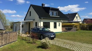 Ett tvåvåningshus med en bil parkerad på uppfarten.