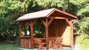 A wooden gazebo with a sloped roof and a bench. - Comfortable, romantic vacation home right at a national park (Jakubovany)