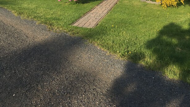 A house with a paved driveway, surrounded by well-maintained grass and flowering plants. - Quiet Holiday home in the middle of the Volcano Eifel (Rheinland-Pfalz)