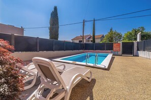 A swimming pool with lounge chairs, a fenced area, and a clear sky. - Suite& Pool (without kitchen) (malinska)