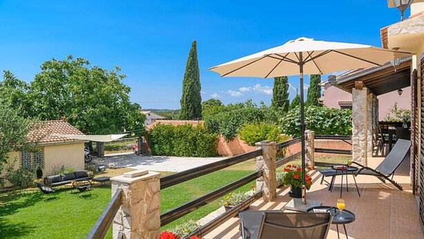 Una terraza con asientos al aire libre, una mesa y una sombrilla.