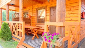 Eine Holzhütte mit einer Holzdiele, einem Tisch und Stühlen.