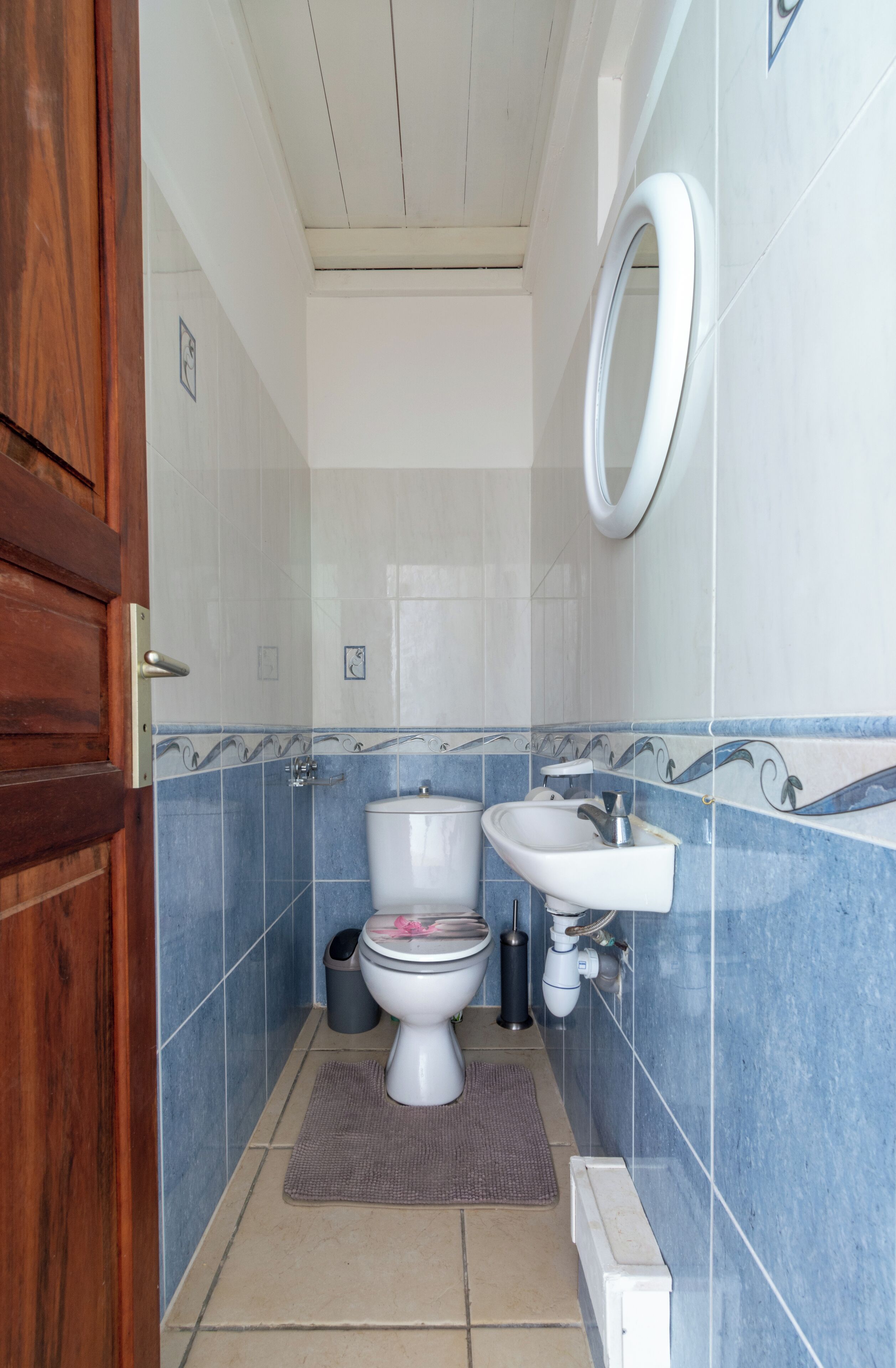 Un bagno con il water, un lavandino e uno specchio.