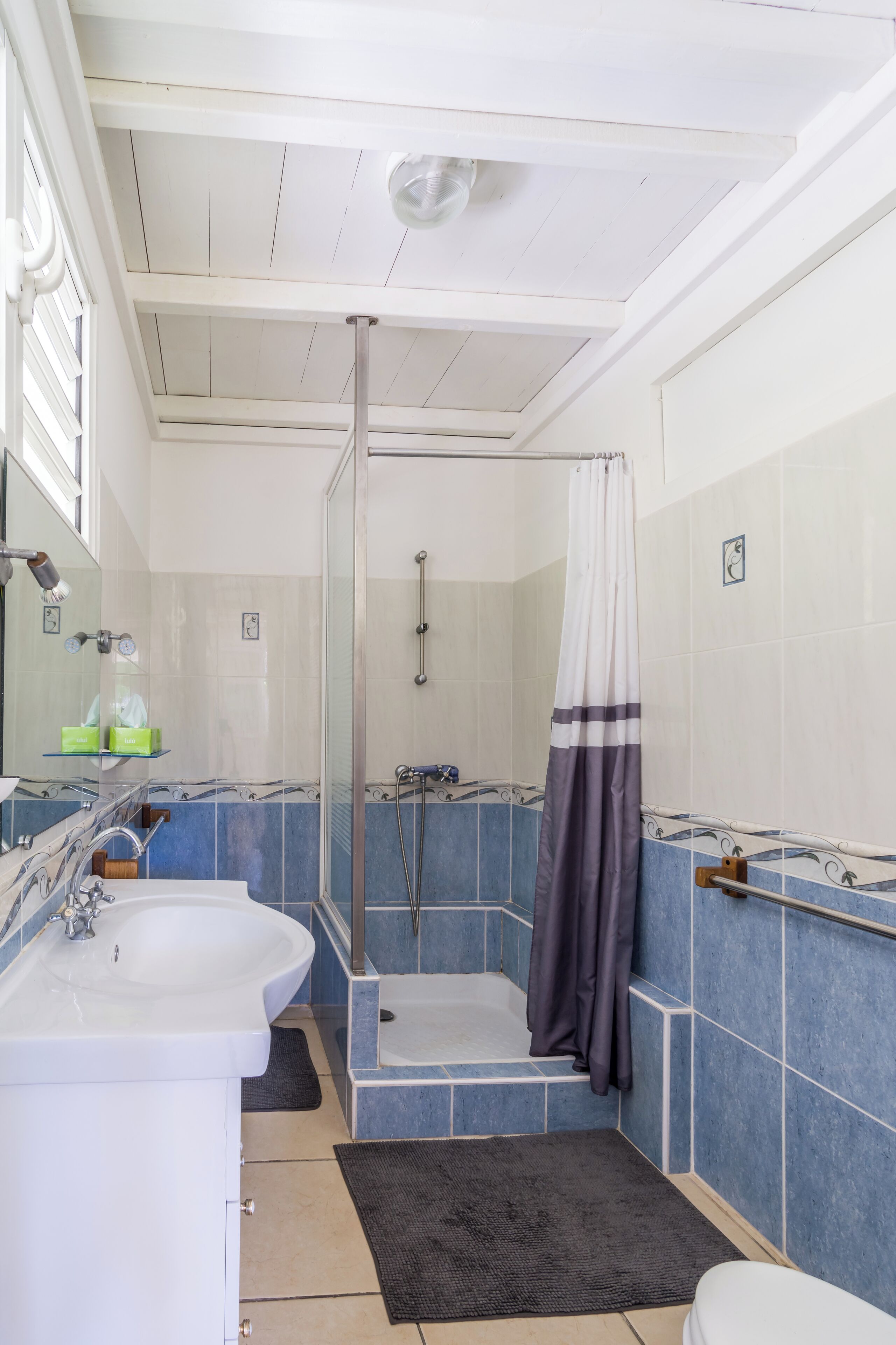 A bathroom with a white sink, a glass shower enclosure, and a bathtub.