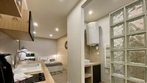 Una cocina moderna con encimera de madera, horno empotrado y un lavamanos.