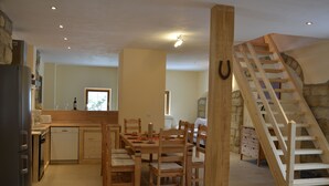 A spacious kitchen with wooden furniture, a dining area, and a wooden staircase. - Vacation home at the Bärenstein for 2-8 persons with 140 m² living space, sauna (Struppen)