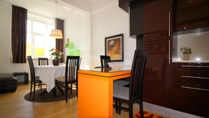 A dining area with a table, chairs, and a kitchen area with cabinets. - 2-4 persons, modern furnishings, air-conditioned, washing machine (Porec)